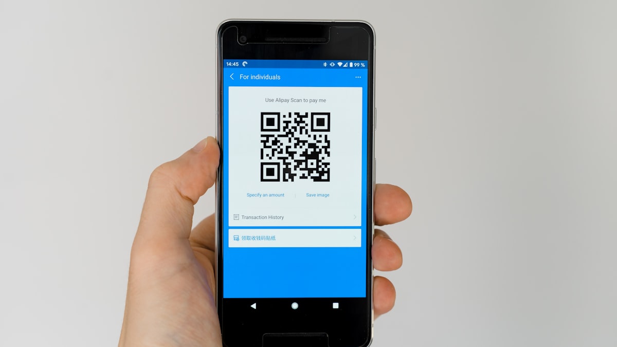 印度商户收款台上的 UPI 二维码，顾客用手机扫码完成支付